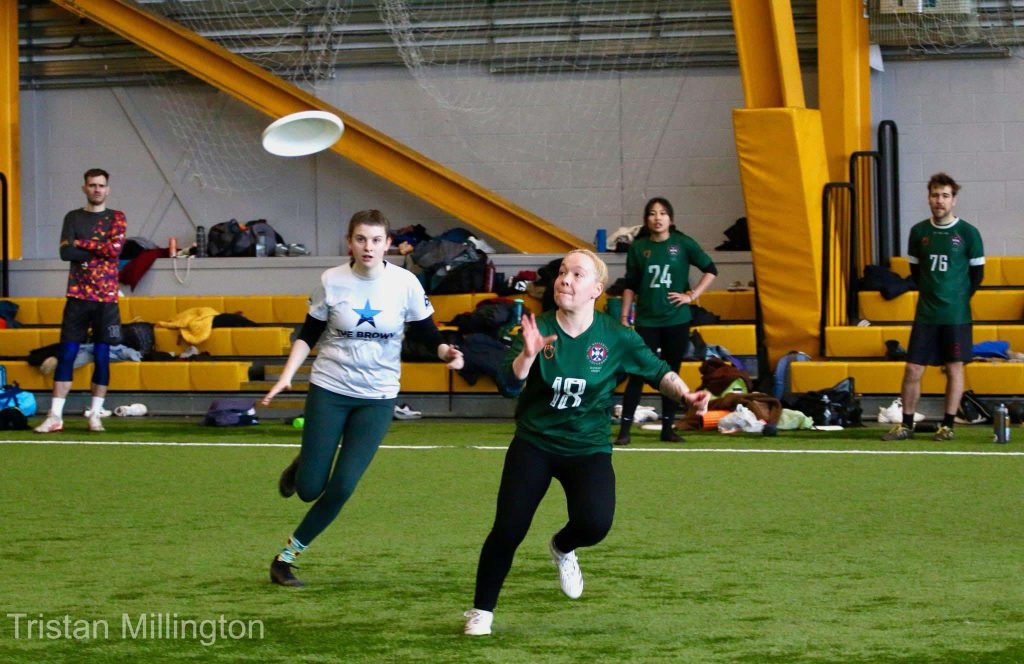 Photo by Tristan Millington. Edinburgh player looking at a disc as it flies towards her, ready to catch it. 