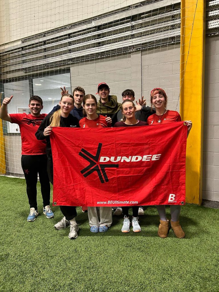 Dundee players holding a Dundee ultimate frisbee flag at Ravenscraig. 